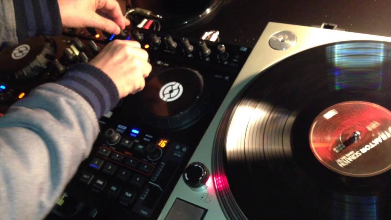 A DJ using DJ equipment to mix tracks.